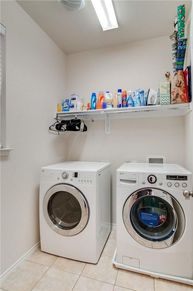 Clothes washing area with separate washer and dryer and light tile patterned floors | Image 16