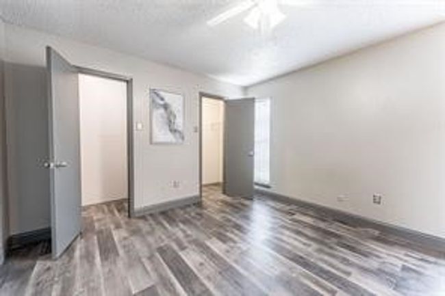Unfurnished bedroom with wood finished floors and a ceiling fan | Image 17