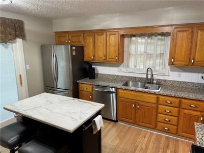 Kitchen featuring light hardwood and appliances with stainless steel finishes | Image 2