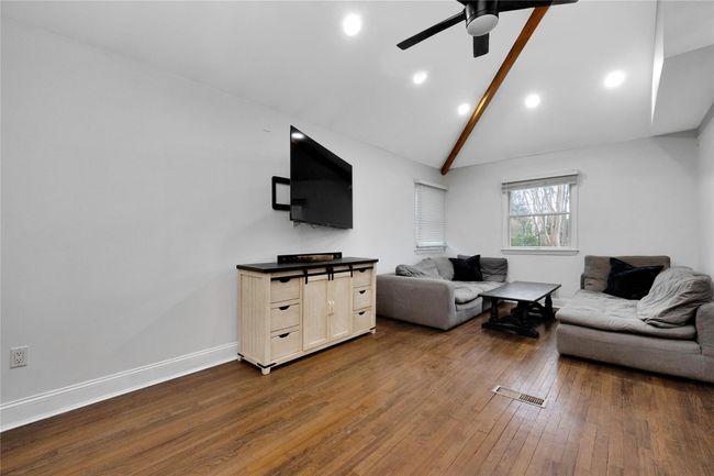 Living area featuring high vaulted ceiling, a ceiling fan, baseboards, and dark wood-style flooring | Image 7