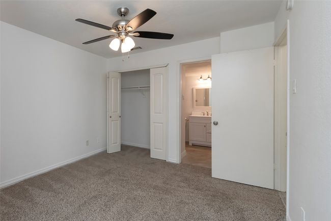 Unfurnished bedroom with visible vents, a closet, a sink, a ceiling fan, and carpet | Image 11
