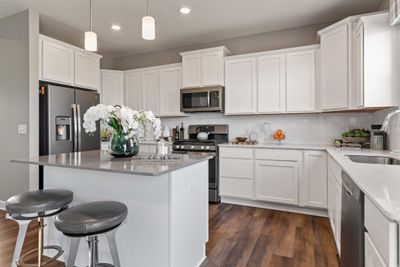 (Photo of decorated model, actual home's finishes will vary) This spacious kitchen features a large center island, quartz countertops, recessed lighting, LVP floors, stainless appliances and more. | Image 2