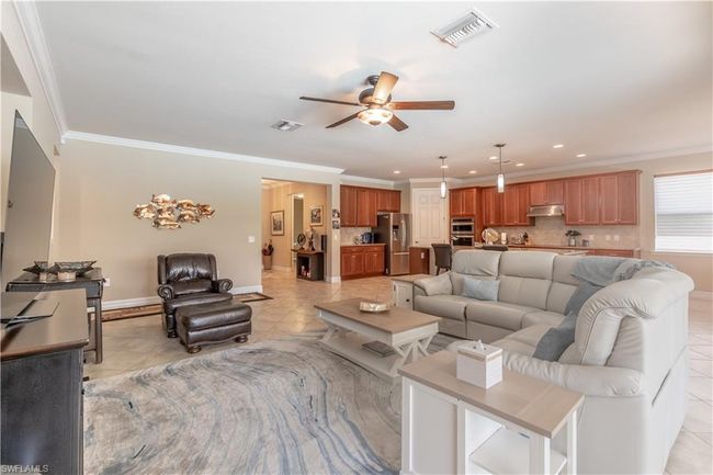 Bedroom with light tile patterned floors, ceiling fan, and a raised ceiling | Image 24