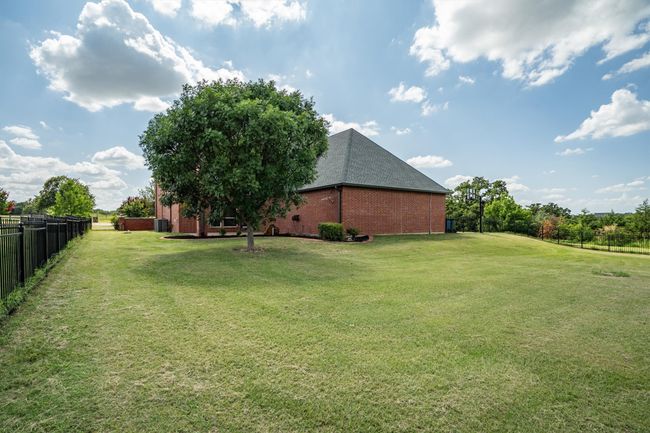 Expansive greenspace is dotted with mature trees, creating a peaceful, park-like setting that offers both beauty and privacy. | Image 32