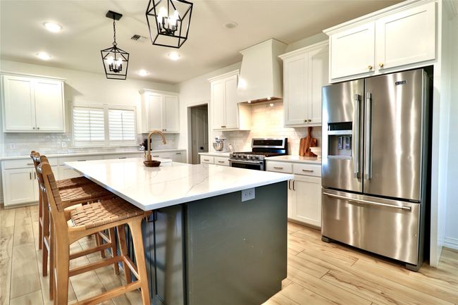 Kitchen with stainless steel appliances, a sink, visible vents, decorative backsplash, and premium range hood | Image 10