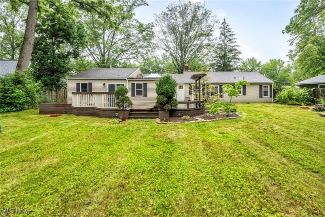 Back of house with a chimney, a deck, and a yard | Image 38