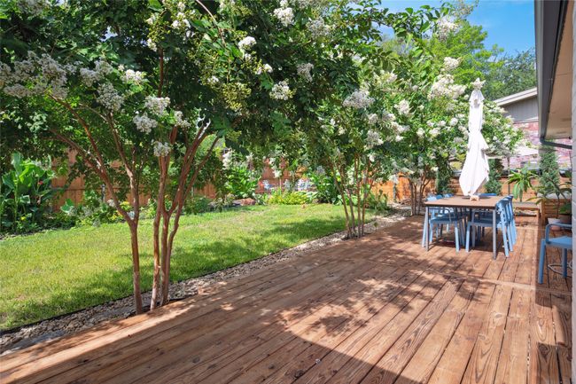 Full width wooden backyard patio overlooks landscaped backyard. | Image 22