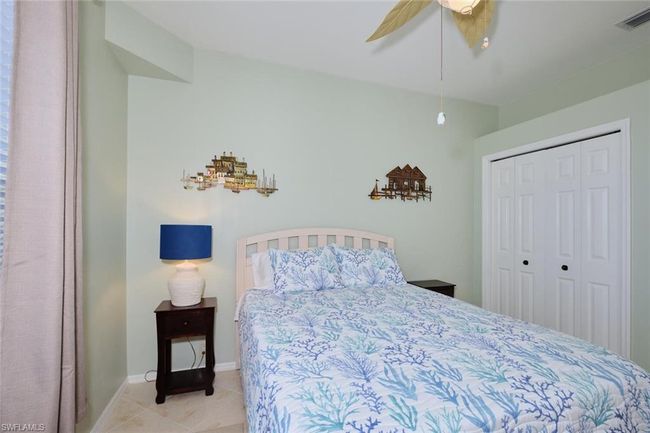 Tiled bedroom with ceiling fan and a closet | Image 44