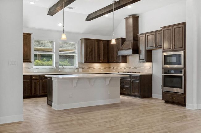 Kitchen with visible vents, custom range hood, a kitchen island, appliances with stainless steel finishes, and light countertops | Image 14