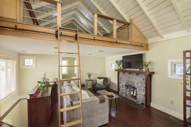 A view of the living area/great room from the kitchen, notice the loft access. | Image 11