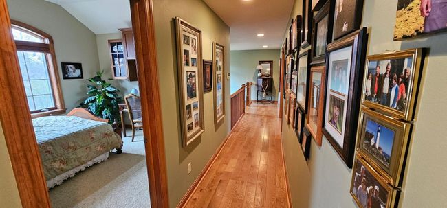 Upper oak hardwood floor hallway with access to both upper bedrooms, upper-level full bath and billiard / craft room. | Image 32
