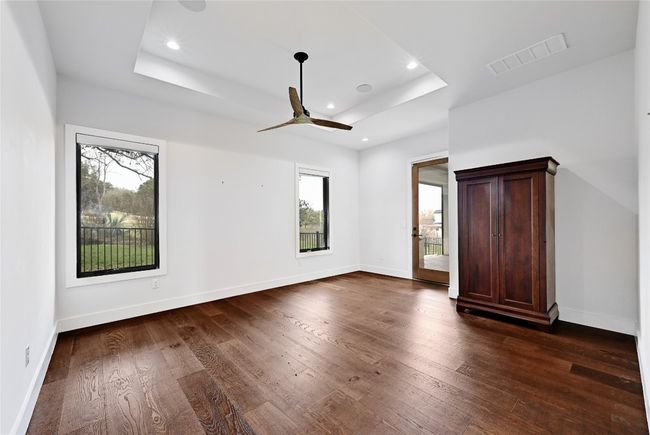 Unfurnished bedroom featuring visible vents, a raised ceiling, dark wood-type flooring, and baseboards | Image 15