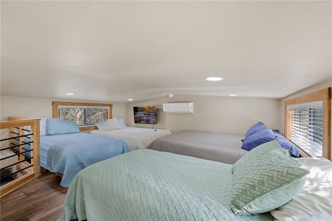 Bedroom featuring wood finished floors and a wall unit AC | Image 11