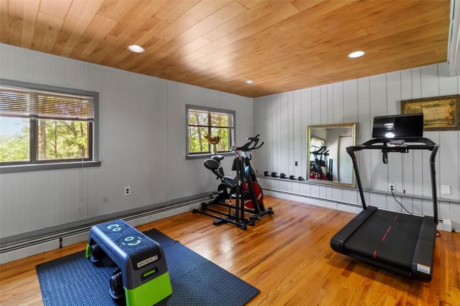 Workout room featuring wood ceiling, wood finished floors, and recessed lighting | Image 14