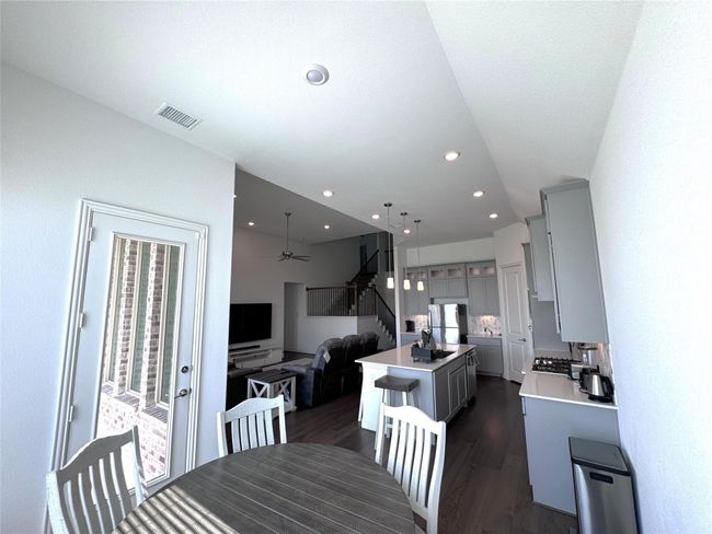 Dining room with stairs, dark wood-style flooring, ceiling fan, and recessed lighting | Image 5