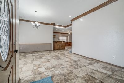 Foyer with ceiling fan with notable chandelier and ornamental molding | Image 3