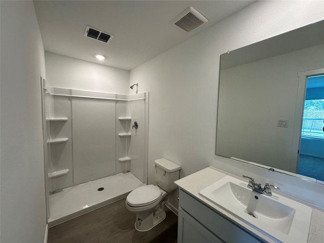 Full bathroom featuring toilet, a walk in shower, vanity, and wood finished floors | Image 14