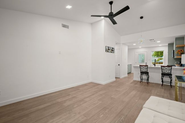 Living area with ceiling fan, light wood-style flooring, high vaulted ceiling, and recessed lighting | Image 5
