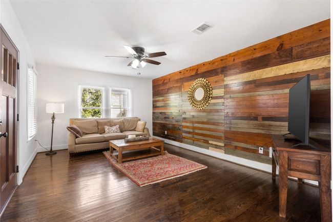 Living room featuring wood walls, a ceiling fan, and wood finished floors | Image 6