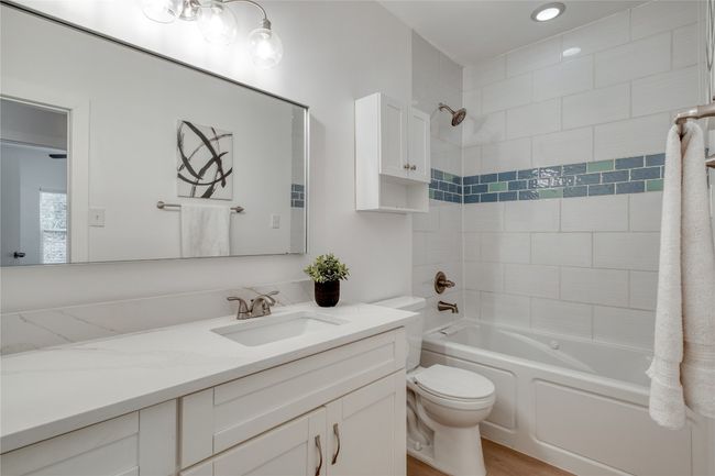 Bathroom featuring vanity, shower / bathtub combination, and wood finished floors | Image 13