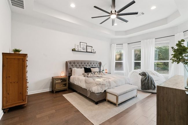 Bedroom with a tray ceiling, dark wood finished floors, recessed lighting, and ceiling fan | Image 20