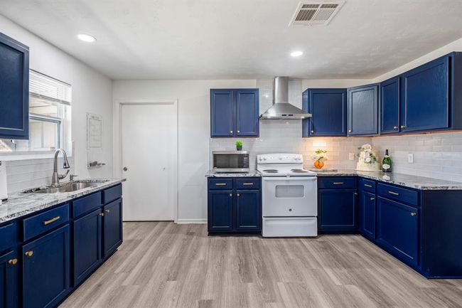 Plenty of counter space, cabinetry, and open flow make this kitchen a functional hub of the home. | Image 12