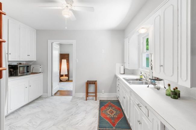 View of kitchen into dining, showing width of space and ample storage | Image 17