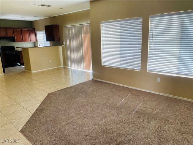Unfurnished living room with light tile patterned floors, visible vents, light carpet, and baseboards | Image 9