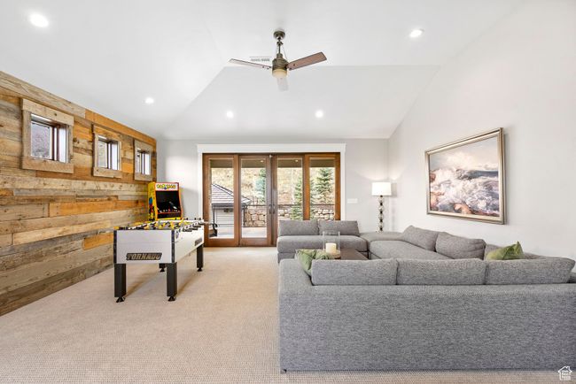 Living area featuring a ceiling fan, wooden walls, recessed lighting, light carpet, and lofted ceiling | Image 60