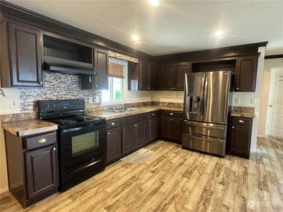 The kitchen is directly connected with the rest of the living area in this wonderful home. | Image 3