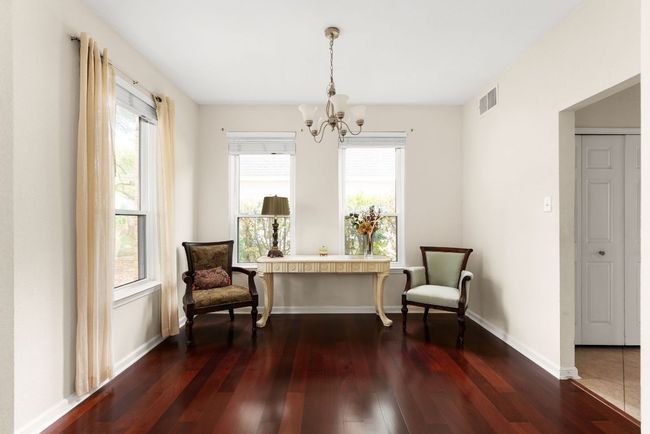 Living area featuring visible vents, plenty of natural light, a notable chandelier, and dark wood finished floors | Image 13