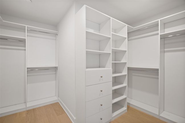 Walk in closet with light wood-style floors | Image 19