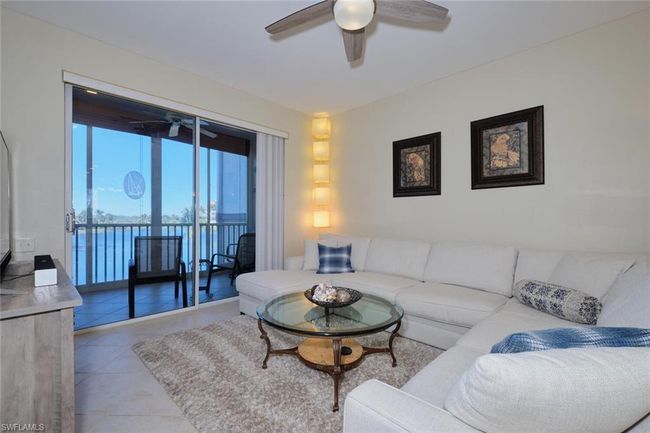Tiled living room with ceiling fan and a water view | Image 27