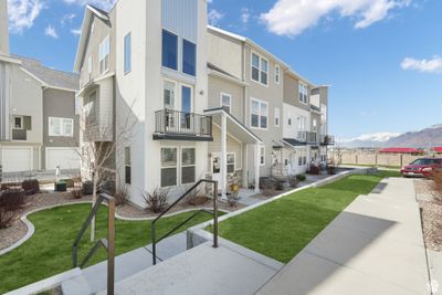 View of building exterior featuring a mountain view, a garage, and central AC | Image 1