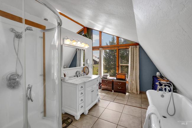 Full bathroom featuring lofted ceiling, vanity, a tub to relax in, a shower stall, and a textured ceiling | Image 26