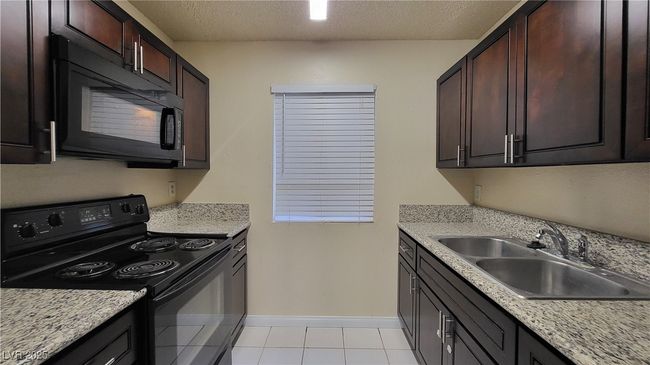 Kitchen featuring black appliances, light countertops, and a sink | Image 4
