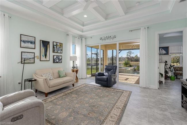 Living room with beam ceiling, ceiling fan, crown molding, and coffered ceiling | Image 5