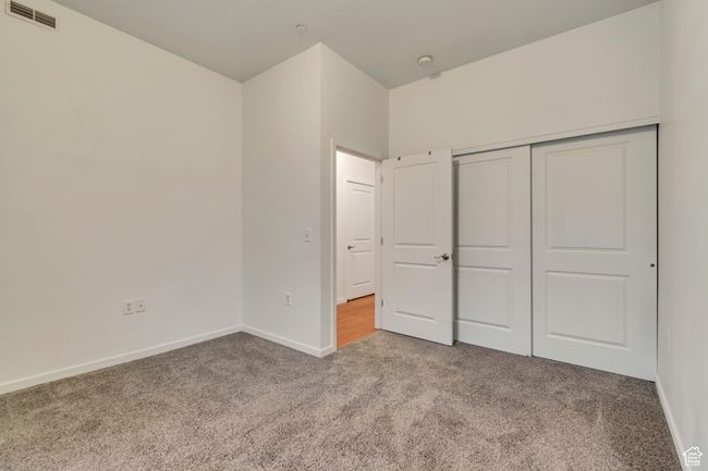 Unfurnished bedroom with baseboards, visible vents, a closet, and carpet | Image 23