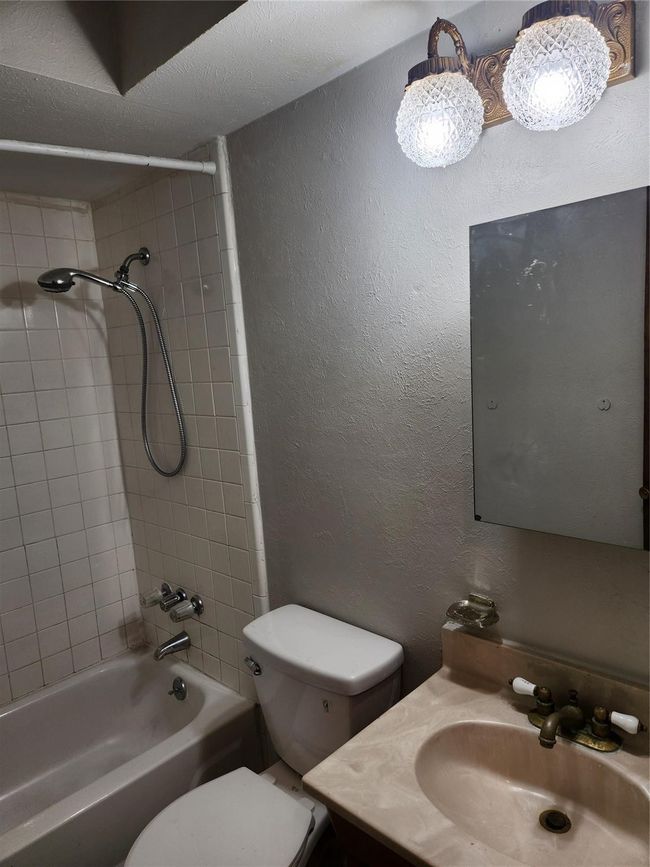 Full bath with toilet, vanity, tub / shower combination, and a textured wall | Image 14