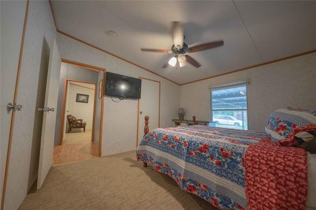 Bedroom featuring carpet, ceiling fan, lofted ceiling, and ornamental molding | Image 20