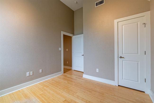 Unfurnished bedroom featuring light wood-style flooring and a high ceiling | Image 11
