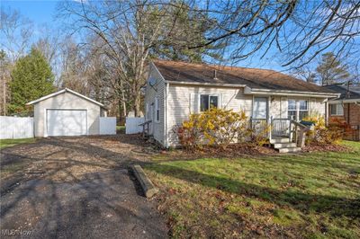 View of front of property featuring a front yard, a garage, and an outdoor structure | Image 3