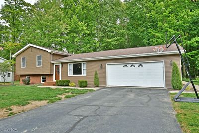 Split level home featuring a front yard and a garage | Image 2