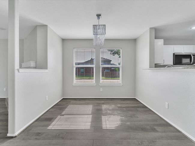 Unfurnished dining area featuring wood finished floors, a chandelier, and baseboards | Image 22