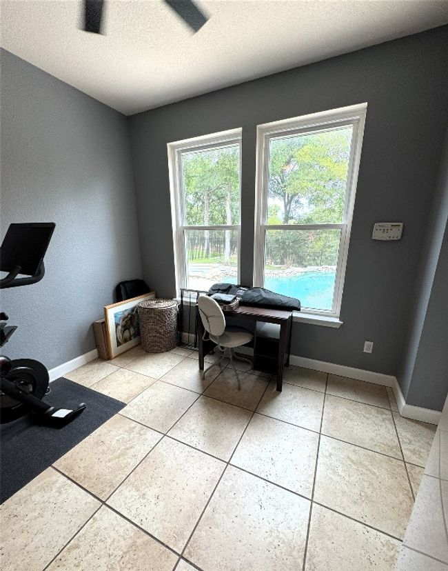 Office space with a textured ceiling and light tile patterned floors. | Image 16