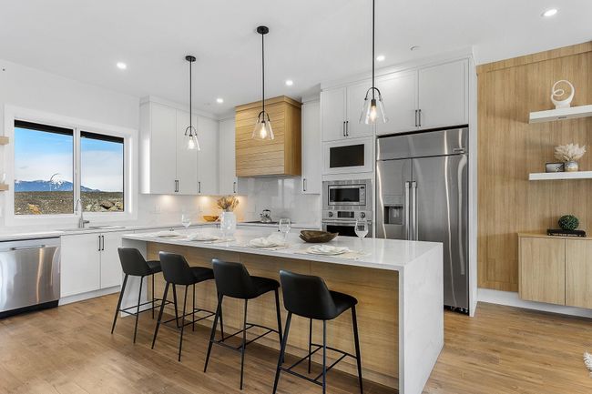 Kitchen featuring appliances with stainless steel finishes, a sink, a kitchen island, a kitchen bar, and recessed lighting | Image 6