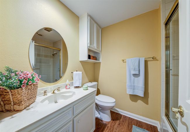 Full bathroom featuring wood finished floors, vanity, and bath / shower combo with glass door | Image 15