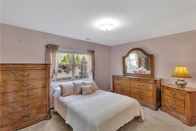 Convenient 14x11 Main Floor Primary Bedroom with Neutral Carpet and Paint. Beautiful View of the Private Yard. | Image 18