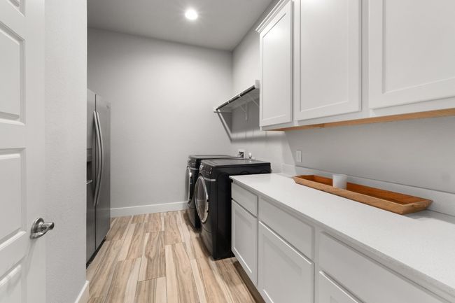 Clothes washing area with recessed lighting, light wood-style floors, baseboards, separate washer and dryer, and cabinet space | Image 31