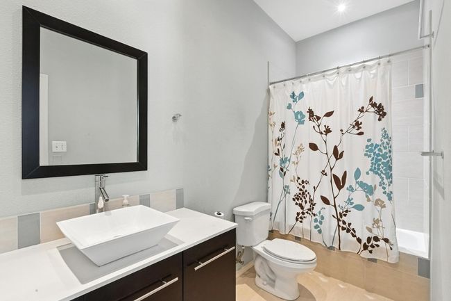 Full bathroom with shower / tub combo, vanity, and tile patterned floors | Image 23